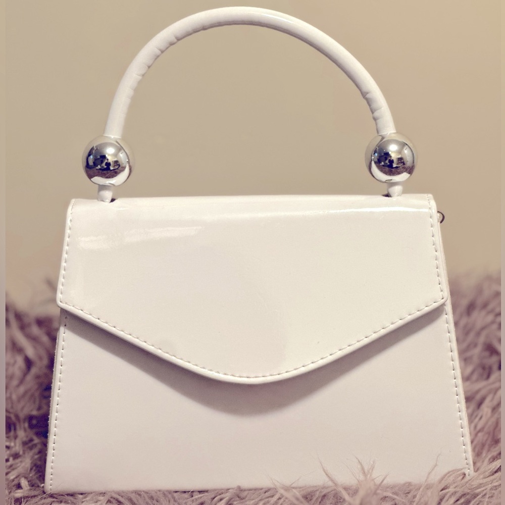 White patent leather vintage style purse with silver detail and cross chain